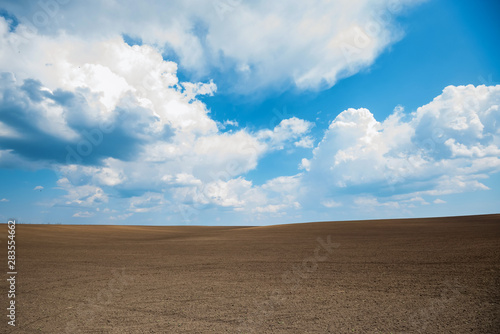 Empty brown soil of field and blue sky for natural background