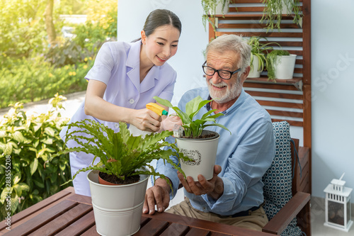 фотографія Caregiver help assist senior old man eldery puring water and taking care small t