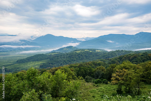 Scenic view of foggy mountains. Clouds and green mountain forest view