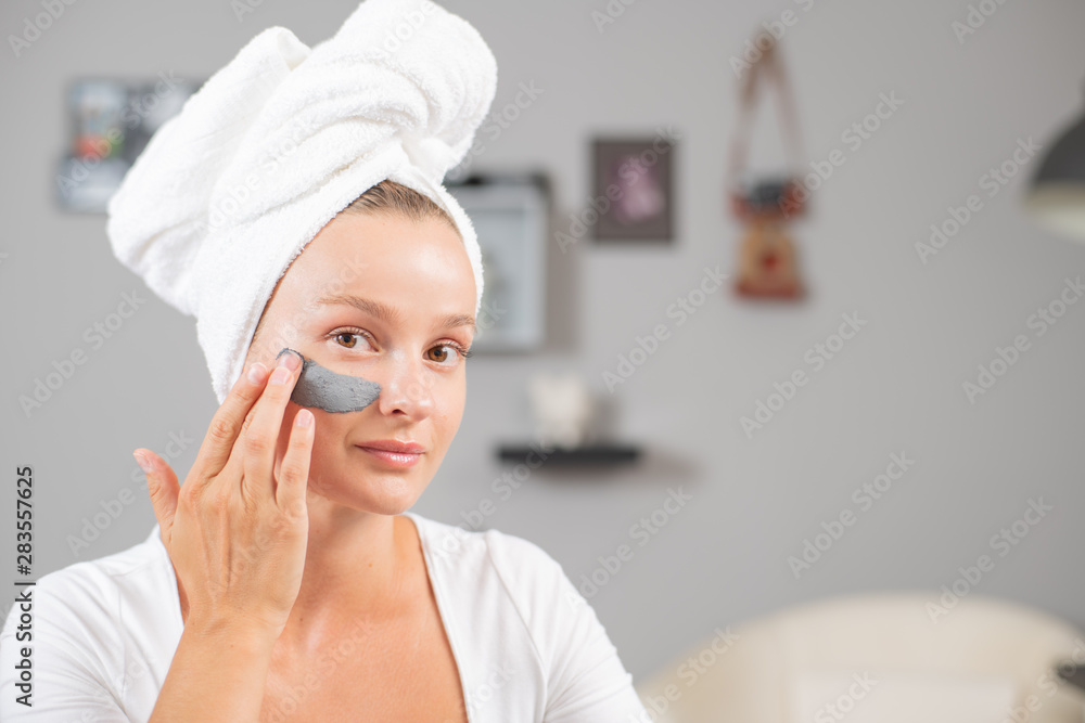 Beautiful woman is applying facial clay mask. Beauty treatments and skincare Beautiful woman is applying facial clay mask. Beauty treatments and skincare