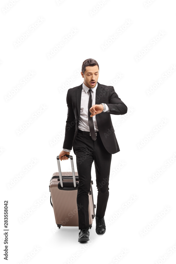 Businessman with a suitcase going on a business trip and checking his watch Businessman with a suitcase going on a business trip and checking his watch