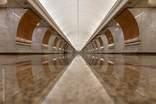 The absence of people in the Park Pobedy station of the Moscow subway brings out the architectural style and the geometries, well reflected symmetrically on the marble floor.