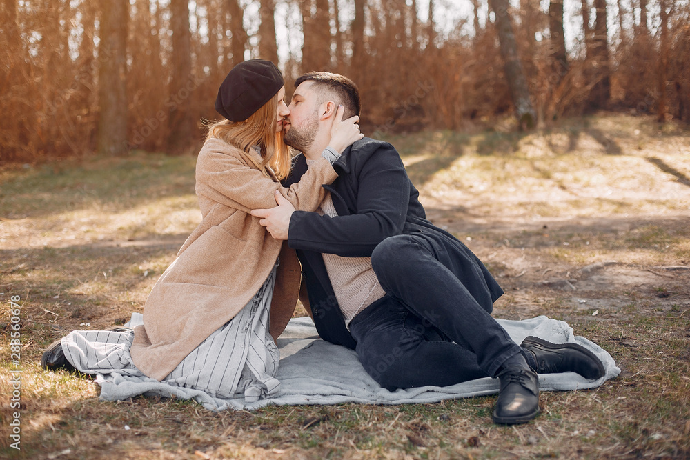 Couple in a park. Blonde in a brown coat. Man with a beard Couple in a park. Blonde in a brown coat. Man with a beard