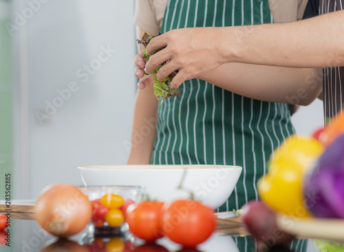 Young Asian couple preparing vegetable for make a fresh salad for their lunch