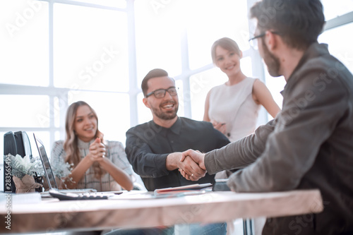 background image of the handshake of business partners in the office photo