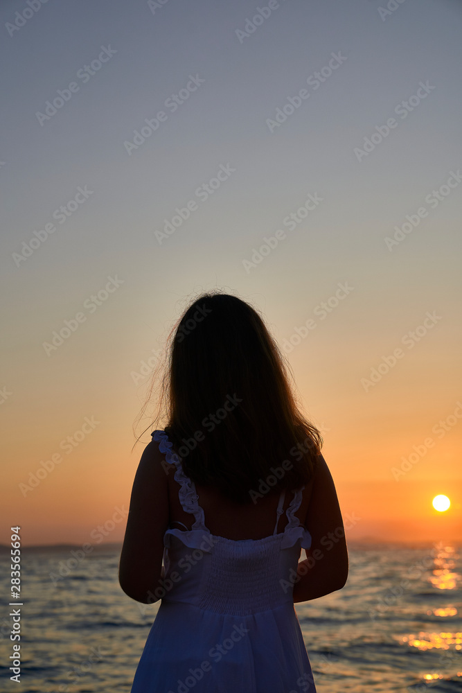 Girl silhouette in the Sunset of Zadar. Croatia. Europe