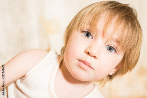 Portrait of little child with beautiful eyes and blond hair.