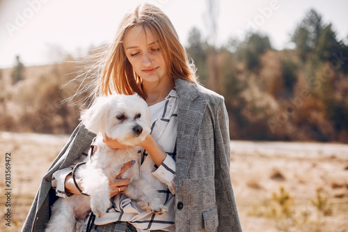 Beautiful girl in a park. Stylish girl with little dog