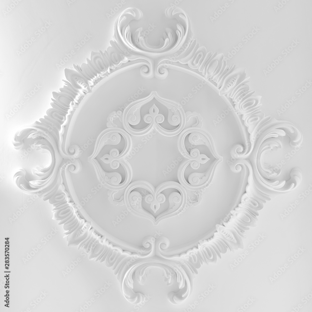 Decorative item made of white plaster on ceiling and wall. Beautiful ornament and relief stucco interior