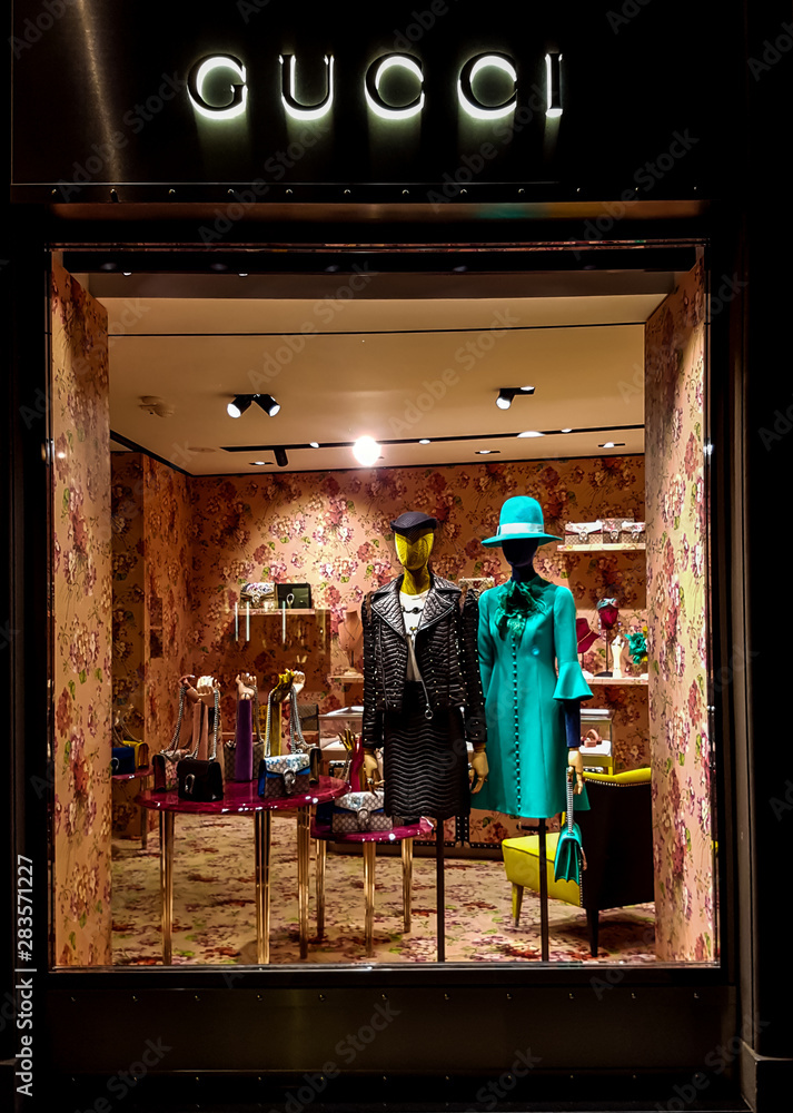 Gucci luxury bags, clothes and shoes sit displayed for sale inside a Gucci  store. at Florence, Italy Stock Photo | Adobe Stock