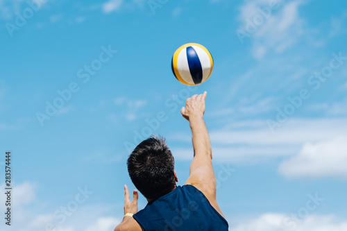 Man playing volleyball in the summertime after corona crisis surcharge blue sky playing with ball fitness © Ronny Friedrich