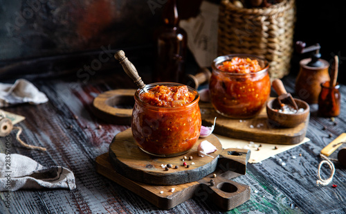 two glass jars with home made red vegetable caviar, ratatouille, ragout on wooden brown boards © Марина Долбус