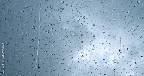 Rain drop on the car glass background.Road view through car window with rain drops, Driving in rain. Abstract traffic in raining day. View from car seat. Concept of: Drive, Fast, Alone, Car, Close up.