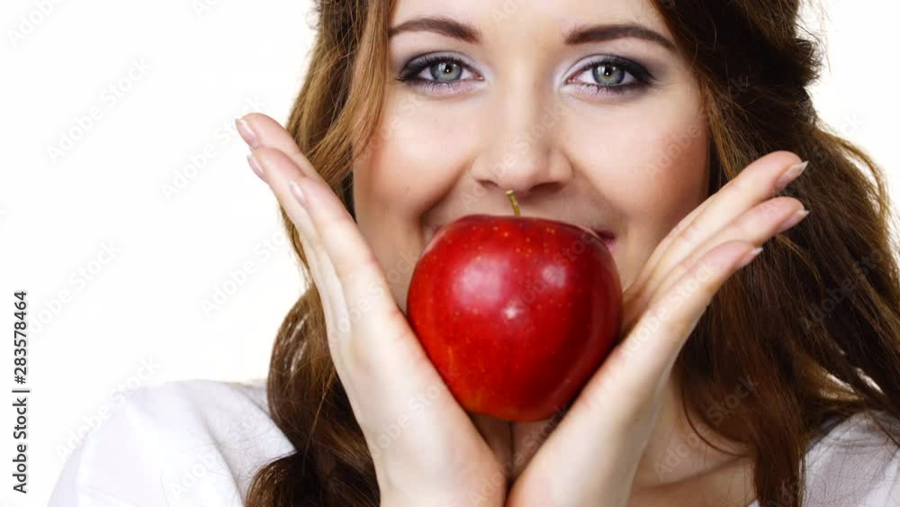 Woman toothy smile brunette female holding red apple fruit in hand close to face, isolated on white. Healthy eating, vegetarian food, diet concept Woman toothy smile brunette female holding red apple fruit in hand close to face, isolated on white. Healthy eating, vegetarian food, diet concept