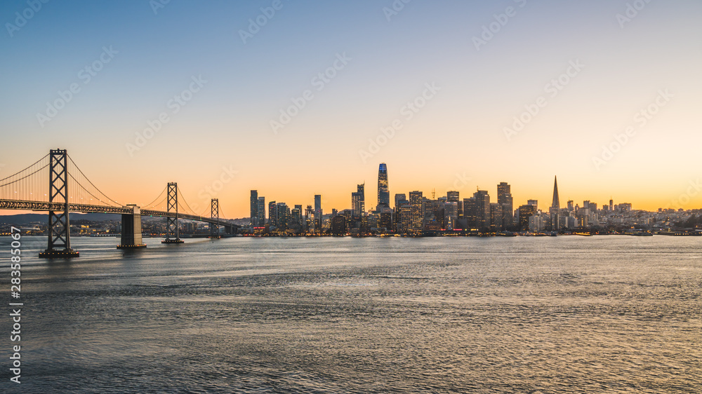 Panoramic beautiful scenic view of the Oakland Bay Bridge and the SF city at dusk, San Francisco, California