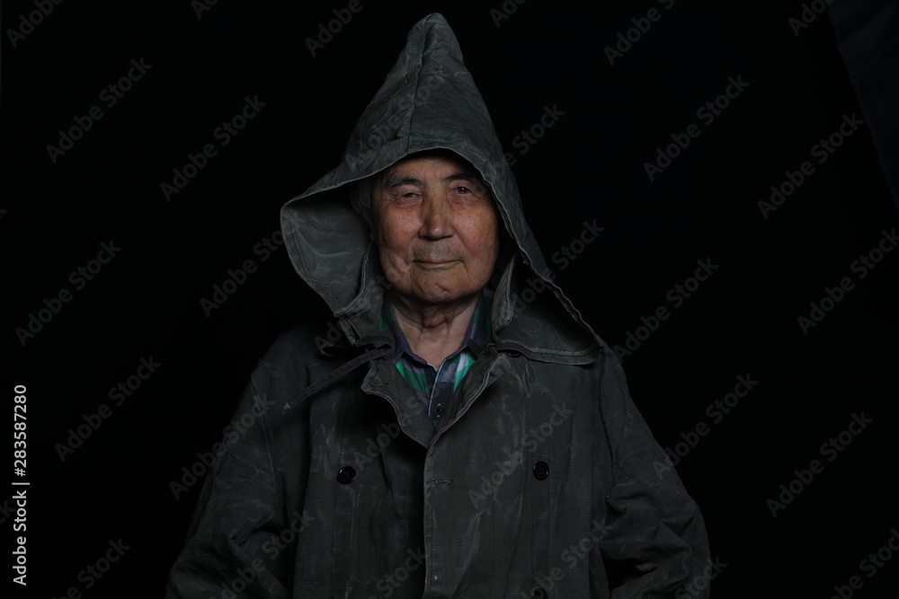 portrait of an old man in a hood on a black background portrait of an old man in a hood on a black background