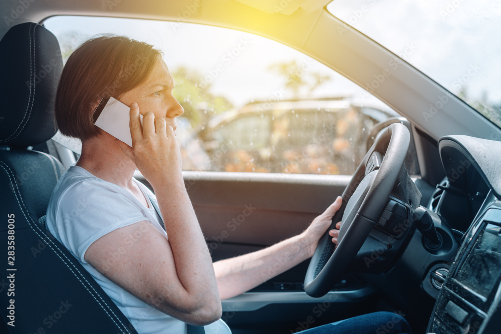 Woman driving car off-road and talking on mobile phone