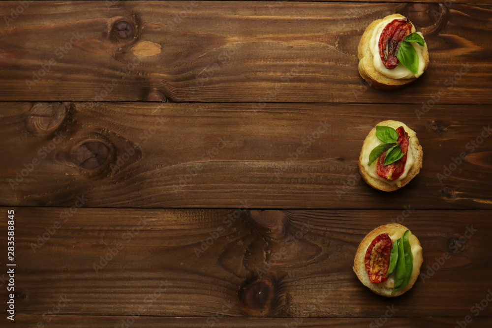Tasty with sun-dried tomatoes on wooden table Tasty with sun-dried tomatoes on wooden table