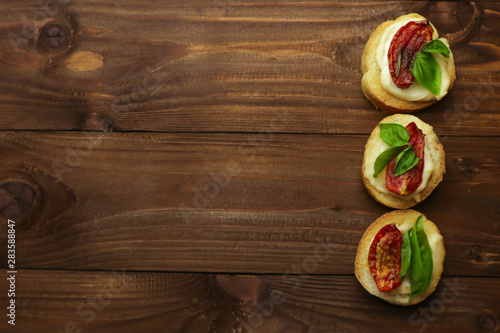 Tasty with sun-dried tomatoes on wooden table