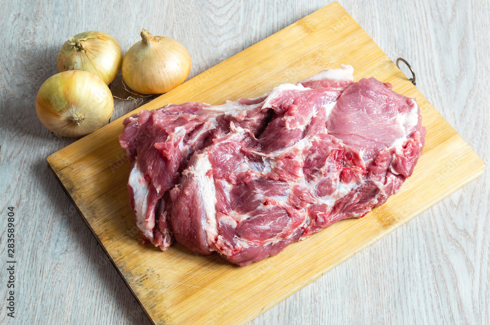 Raw meat and onion on wooden board Raw meat and onion on wooden board