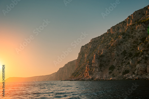 Sunset and Steep Cliffy Rocky Sea Shore. Sea and Rocks.