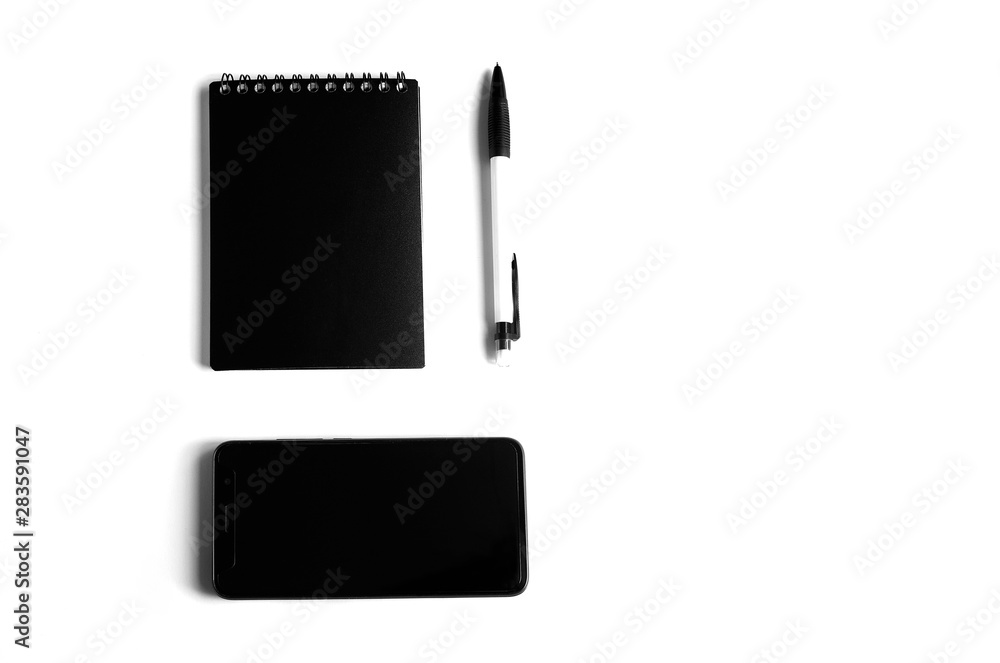 Black and white concept. Business concept with mobile phone, notebook and pen on a white background. Flat lay. Minimalaizm. Black and white concept. Business concept with mobile phone, notebook and pen on a white background. Flat lay. Minimalaizm.
