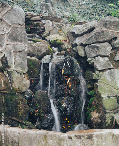 Small waterfall flowing along a stone wall