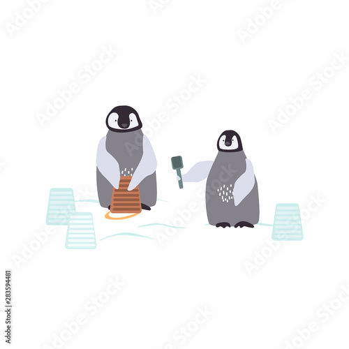 Canvas Print Two cartoon penguins are bulding a snowcastle
