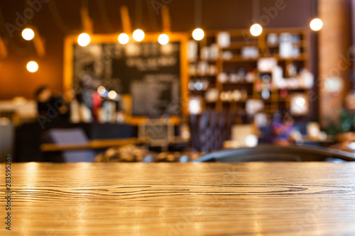Wooden top table with blurred of coffee shop background. Mockup wooden desk for display or montage your products. Blur in coffee shop or cafe  restaurant background.