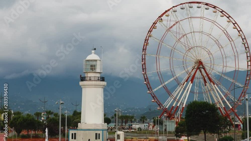 timelapse Ferris wheel and Batumi lighthouse on the Batumi Seafront Promenade in the cloudy day, Adjara.