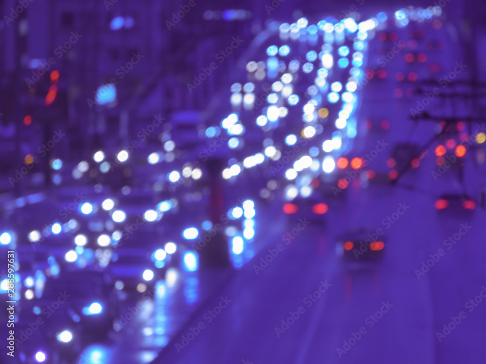 Fototapeta premium Defocused image of hard night for drivers. Big traffic in the city. In the summer urban highway filled cars. To be late. Long exposure. For greeting card design, postcard template, guide, poster.