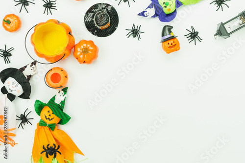 Table top view aerial image of decoration Happy Halloween day background concept.Flat lay accessories essential object to party the pumpkin & doll and hat on white wooden.Space for creative design.