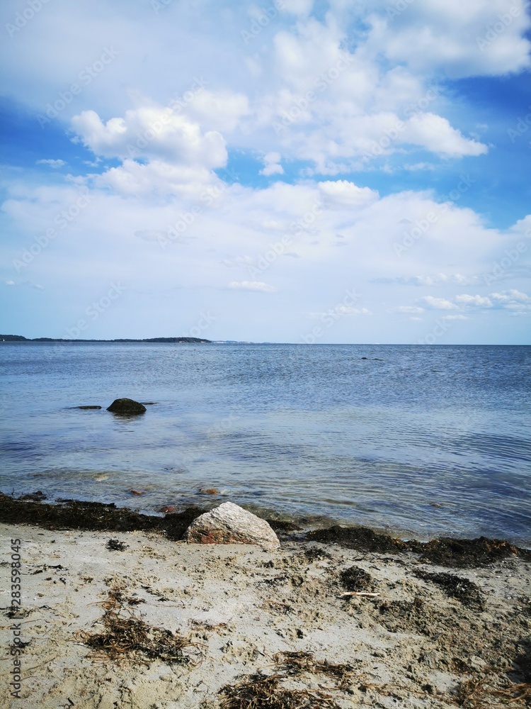 beach from the island rügen on the baltic sea with blue water and white clouds