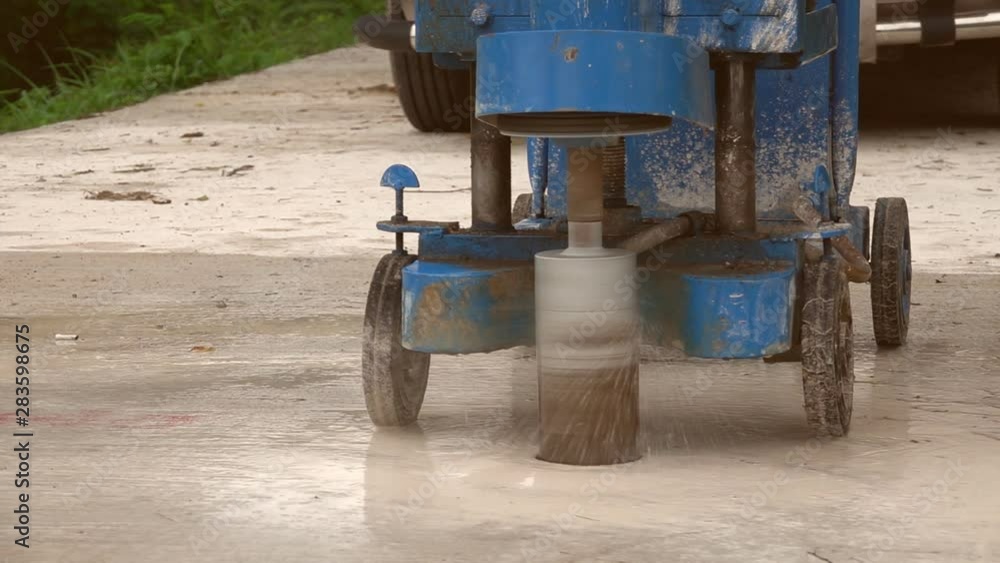 Closeup of a machine core drilling a hole in concrete on a construction site Closeup of a machine core drilling a hole in concrete on a construction site