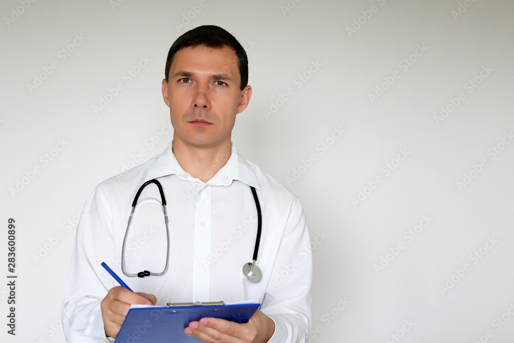 Doctor with stethoscope writes a prescription standing on white background. Portrait of male physician, concept of medicine, therapist, examination at the clinic, health care Doctor with stethoscope writes a prescription standing on white background. Portrait of male physician, concept of medicine, therapist, examination at the clinic, health care