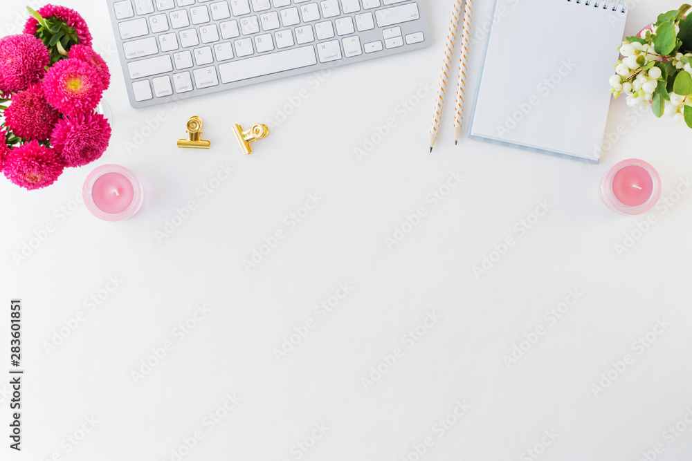 Flat lay blogger or freelancer workspace with a notebook, keyboard and pink flowers on a white background Flat lay blogger or freelancer workspace with a notebook, keyboard and pink flowers on a white background