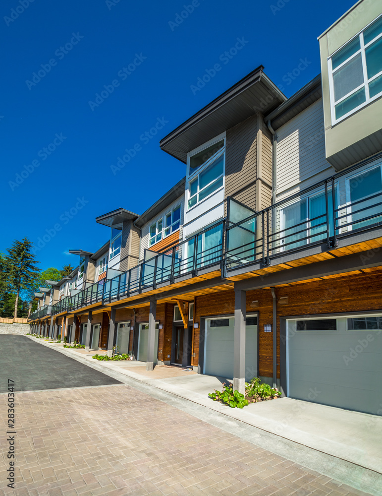 Row of brand new townhouses on sunny day.