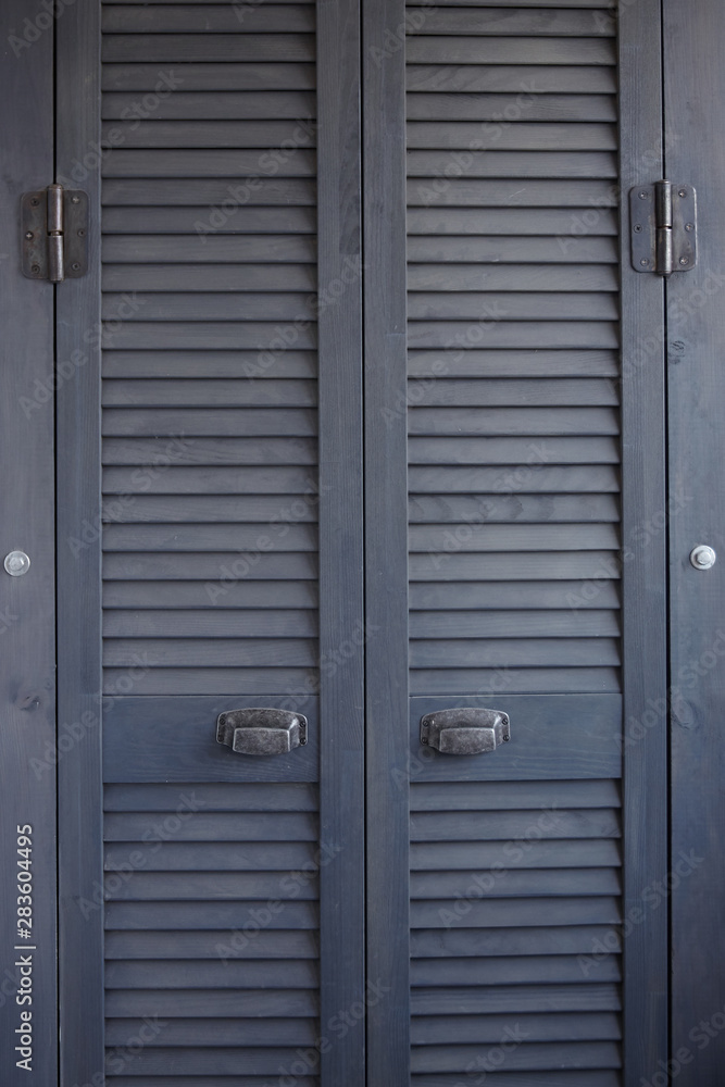 Close-up dark gray shutter doors with frayed metal handles, Scandinavian minimalist cabinet interior, selective focus Close-up dark gray shutter doors with frayed metal handles, Scandinavian minimalist cabinet interior, selective focus