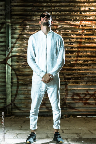 portrait of young dj in white clothes against textured background