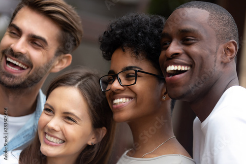 Smiling multiracial millennial friends posing for picture together