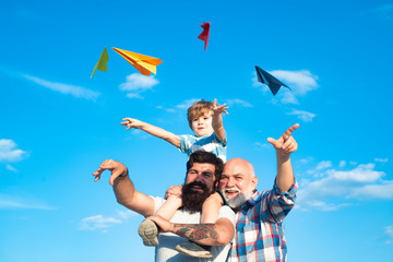 Young boy with father and grandfather enjoying together on blue sky background. Enjoy family together. Father and son with grandfather - happy loving family.