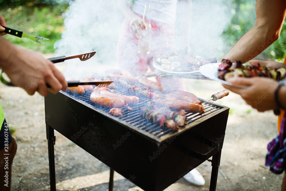 Happy friends enjoying barbecue and grill party outdoor Happy friends enjoying barbecue and grill party outdoor