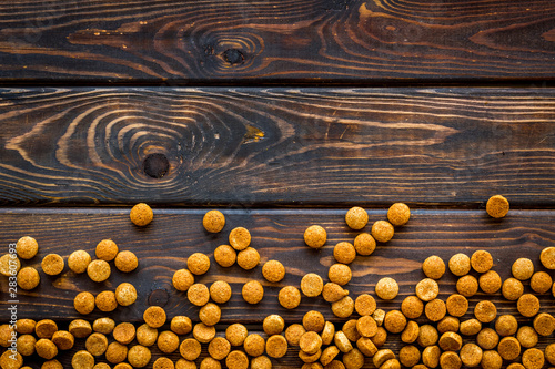 Cat dry food on wooden background top view copyspace
