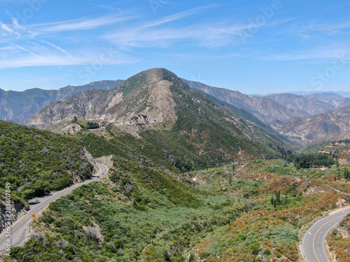 Asphalt road bends through Angeles National forests mountain, California, USA. Thin road winds between a ridge of hills and mountains at high altitude