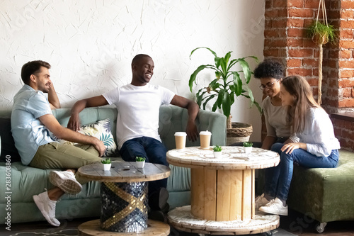 Smiling diverse young people get acquainted in cafe photo