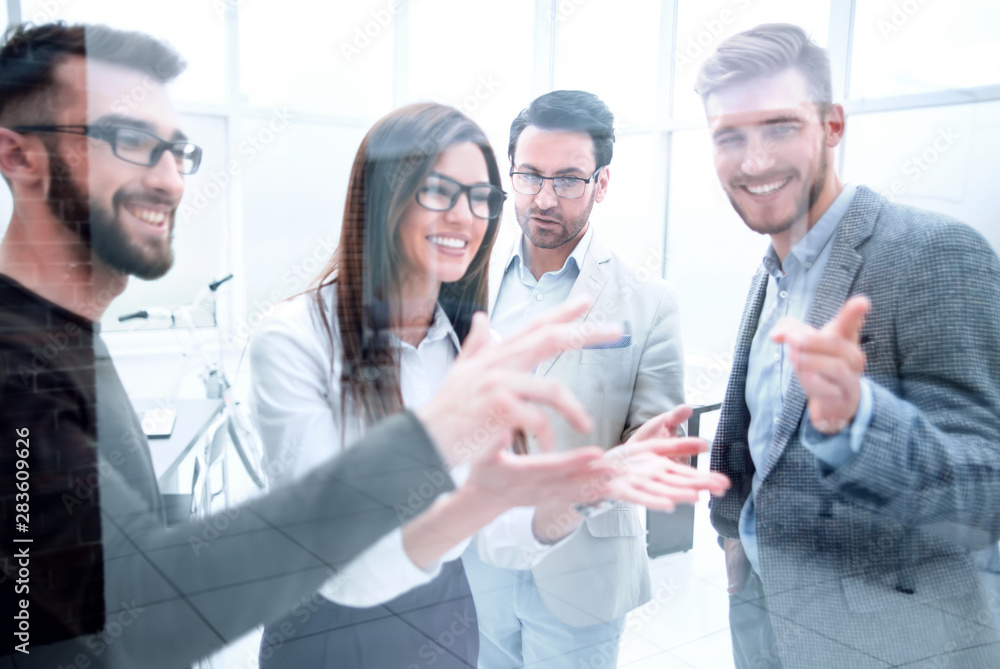 smiling staff discussing something standing in the office. smiling staff discussing something standing in the office.
