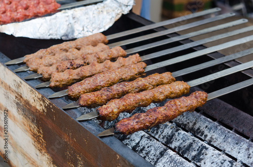 Fotografie Cooking adana kebabs on a grill in restaurant