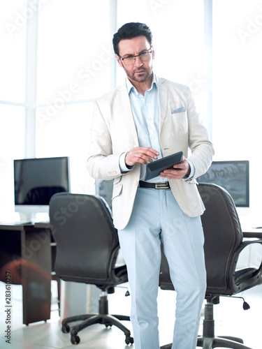 businessman with calculator standing in an empty office