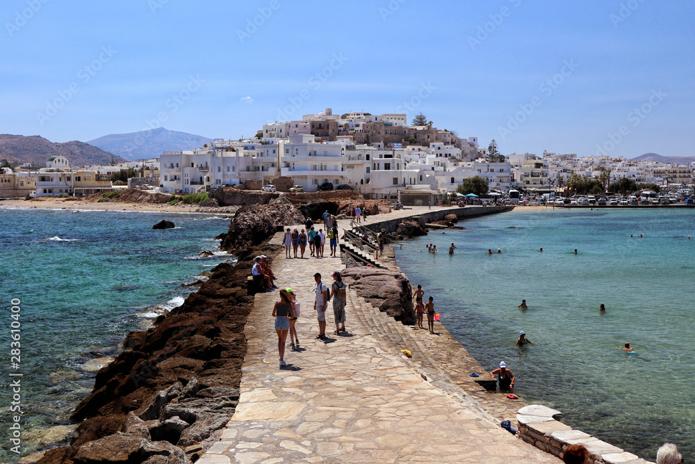 Naxos town and causeway across turquoise Aegean Sea from the Islet of Palatia, Naxos, Greek Islands