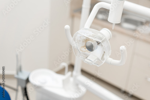 Close-up dentist lamp. Dental work in clinic. Operation, tooth replacement. Medicine, health, stomatology concept. Office where dentist conducts inspection and concludes.